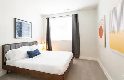 a bedroom with a bed and a large window at CozySuites at ArtCincy in Cincinnati