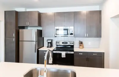 a kitchen with stainless steel appliances and a sink at CozySuites at ArtCincy in Cincinnati