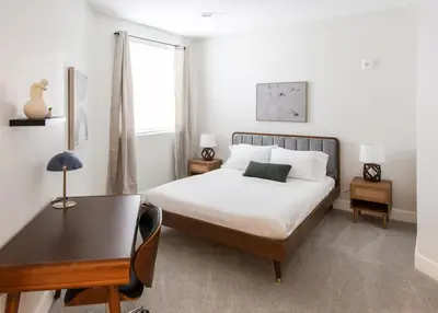 a bedroom with a bed and a table and a desk at CozySuites at ArtCincy in Cincinnati