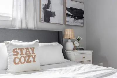 a bed with a pillow with a stay cozy sign on it at Westlake Escape in Westlake