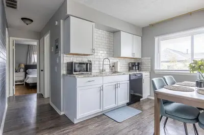 a kitchen with white cabinets and a table with chairs at Westlake Escape in Westlake