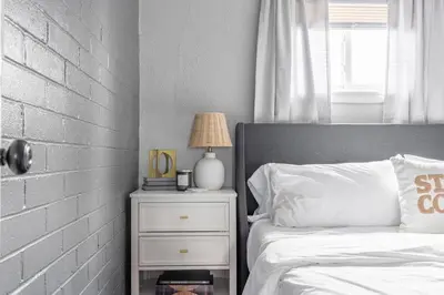a bedroom with a bed and a night stand with a lamp at Westlake Escape in Westlake