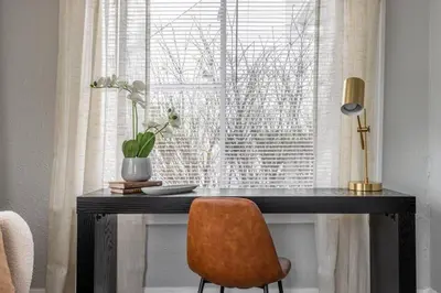 a desk with a chair in front of a window at Quiet Modern Home w/ Hot Tub! in Parma