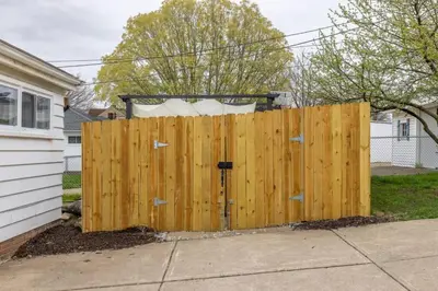 a wooden fence in front of a house at Quiet Modern Home w/ Hot Tub! in Parma