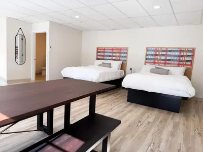 a room with two beds and a wooden table at Explorer Rest & Recreation in Sandusky