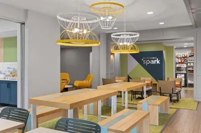 a restaurant with wooden tables and chairs and lights at Spark By Hilton Newcomerstown in Newcomerstown