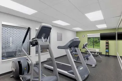 a gym with treadmills and ellipticals in a room at Spark By Hilton Newcomerstown in Newcomerstown