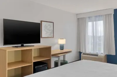 a hotel room with a bed and a television at Spark By Hilton Newcomerstown in Newcomerstown