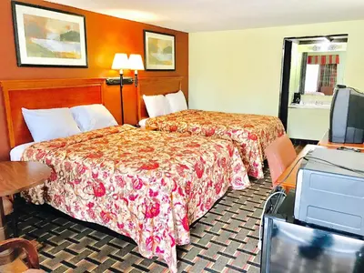 a hotel room with two beds and a television at Greystone Motel in Hillsboro