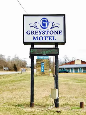 a sign for a greenstone motel in a field at Greystone Motel in Hillsboro