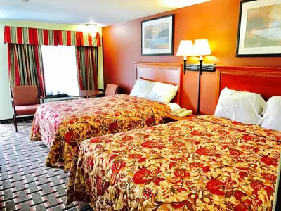 two beds in a hotel room with red walls at Greystone Motel in Hillsboro