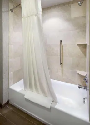 a bathroom with a tub and a shower with a shower curtain at Homewood Suites by Hilton Pittsburgh Airport/Robinson Mall Area in Moon Township