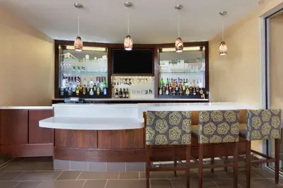 a bar in a hotel room with a tv at Homewood Suites by Hilton Pittsburgh Airport/Robinson Mall Area in Moon Township