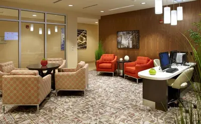 a lobby with a waiting room with chairs and a desk at Homewood Suites by Hilton Pittsburgh Airport/Robinson Mall Area in Moon Township