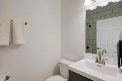 a bathroom with a sink and a toilet and a mirror at Modern Family Home in Mason with Backyard and Fire Pit in Mason