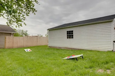 a yard with a building and a surfboard in the grass at Modern Family Home in Mason with Backyard and Fire Pit in Mason