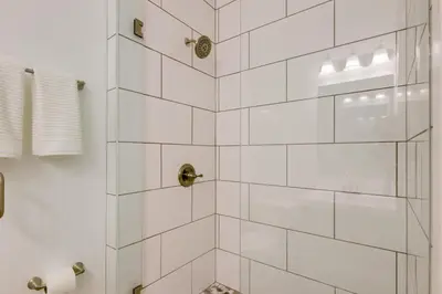 a bathroom with a shower with white tiles at Modern Family Home in Mason with Backyard and Fire Pit in Mason
