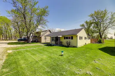 a yellow house in a yard with a yard at Pet-Friendly Ohio Escape with Deck and Community Dock! in Celina