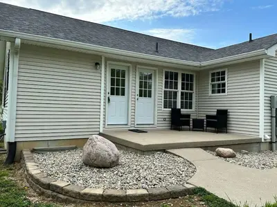 a house with a porch with two rocks in front of it at Suite 1 in Butler