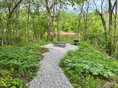 a bench sitting on a gravel path next to a lake at Suite 1 in Butler