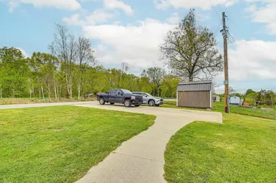 a truck and a car parked on a driveway at Home with Private Pool - 15 miles to Ark Encounter! in Berry
