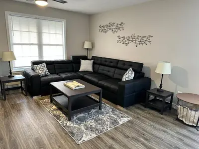 a living room with a black couch and a table at Suite 2 in Butler