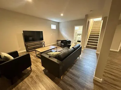 a living room with couches and a flat screen tv at Suite 2 in Butler
