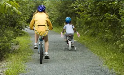 a woman and a child riding bikes down a trail at South Beach Resort Hotel in Marblehead