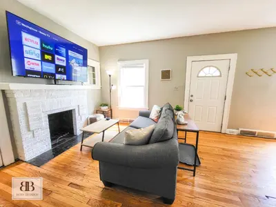 a living room with a couch and a tv at KingBed15 Mins to DTWN, 3 miles to CLE Clinic & CWRU in Cleveland Heights