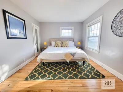 a bedroom with a bed and a rug on the floor at KingBed15 Mins to DTWN, 3 miles to CLE Clinic & CWRU in Cleveland Heights
