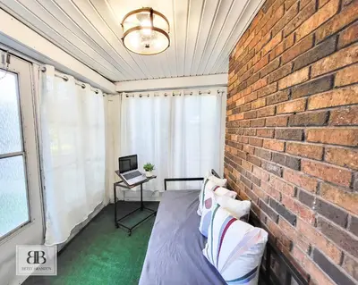 a brick wall in a room with a bed and a laptop at KingBed15 Mins to DTWN, 3 miles to CLE Clinic & CWRU in Cleveland Heights