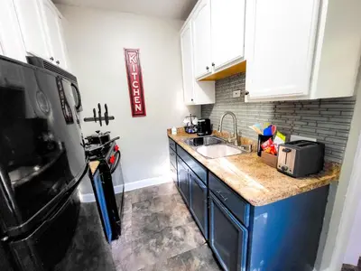 a kitchen with a sink and a black refrigerator at KingBed15 Mins to DTWN, 3 miles to CLE Clinic & CWRU in Cleveland Heights