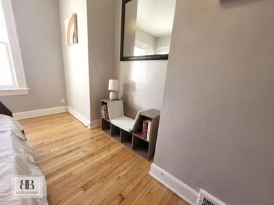 a bedroom with a bed and a mirror on a wall at KingBed15 Mins to DTWN, 3 miles to CLE Clinic & CWRU in Cleveland Heights