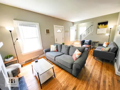a living room with a couch and a table at KingBed15 Mins to DTWN, 3 miles to CLE Clinic & CWRU in Cleveland Heights