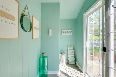 a hallway with blue walls and a window at Walk to Lake Nautical Akron Cottage with Deck! in Uniontown
