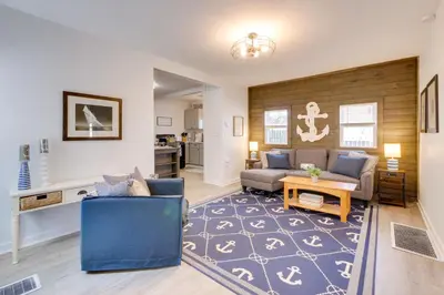 a living room with a couch and a table at Walk to Lake Nautical Akron Cottage with Deck! in Uniontown