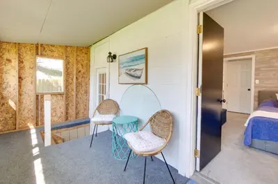 a room with two chairs and a table and a bed at Walk to Lake Nautical Akron Cottage with Deck! in Uniontown