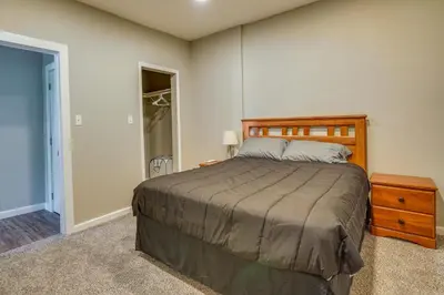 a bedroom with a bed with a wooden headboard at Zanesville Vacation Rental Near Downtown in Zanesville