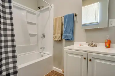 a white bathroom with a sink and a shower at Zanesville Vacation Rental Near Downtown in Zanesville