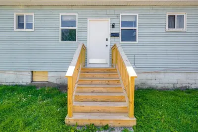 a wooden staircase leading to a house with a door at Zanesville Vacation Rental Near Downtown in Zanesville