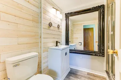 a bathroom with a toilet and a mirror at Indian Lake Vacation Rental with Fire Pit and Sauna in Lakeview