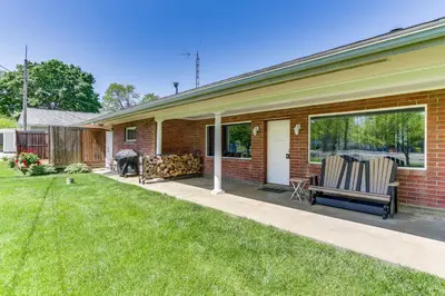 a house with a porch with two chairs on a lawn at Indian Lake Vacation Rental with Fire Pit and Sauna in Lakeview