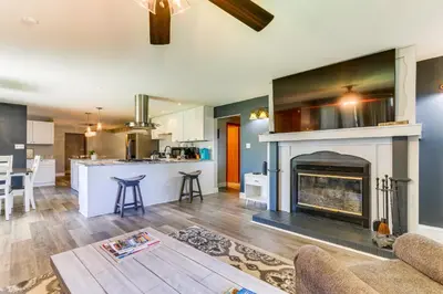 a living room with a fireplace and a kitchen at Indian Lake Vacation Rental with Fire Pit and Sauna in Lakeview