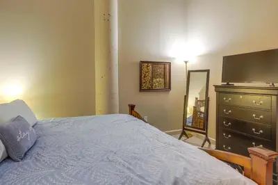 a bedroom with a bed and a dresser with a television at Waterfront Sandusky Vacation Rental Downtown! in Sandusky