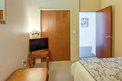 a bedroom with a bed and a desk with a television at Waterfront Sandusky Vacation Rental Downtown! in Sandusky