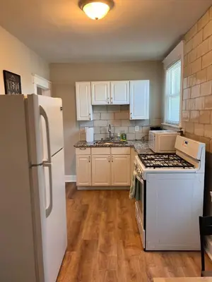 a kitchen with white cabinets and a white refrigerator at Rolston 2, Two Bedroom near Xavier Downtown in Bellevue