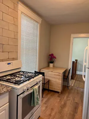 a kitchen with a stove and a table at Rolston 2, Two Bedroom near Xavier Downtown in Bellevue