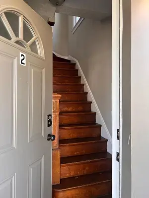 a hallway with a stairway with a white door at Rolston 2, Two Bedroom near Xavier Downtown in Bellevue