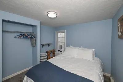 a blue bedroom with a bed and a window at Recharge & Reconnect Your cozy Vermilion nest in Vermilion