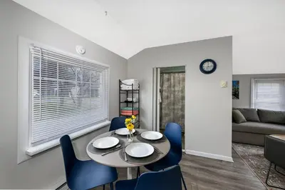 a dining room with a table and blue chairs at Recharge & Reconnect Your cozy Vermilion nest in Vermilion